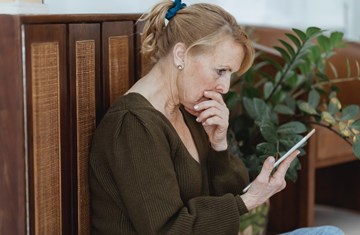 worried looking middle aged woman on phone