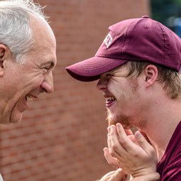 smiling older man and smiling man with Down syndrome