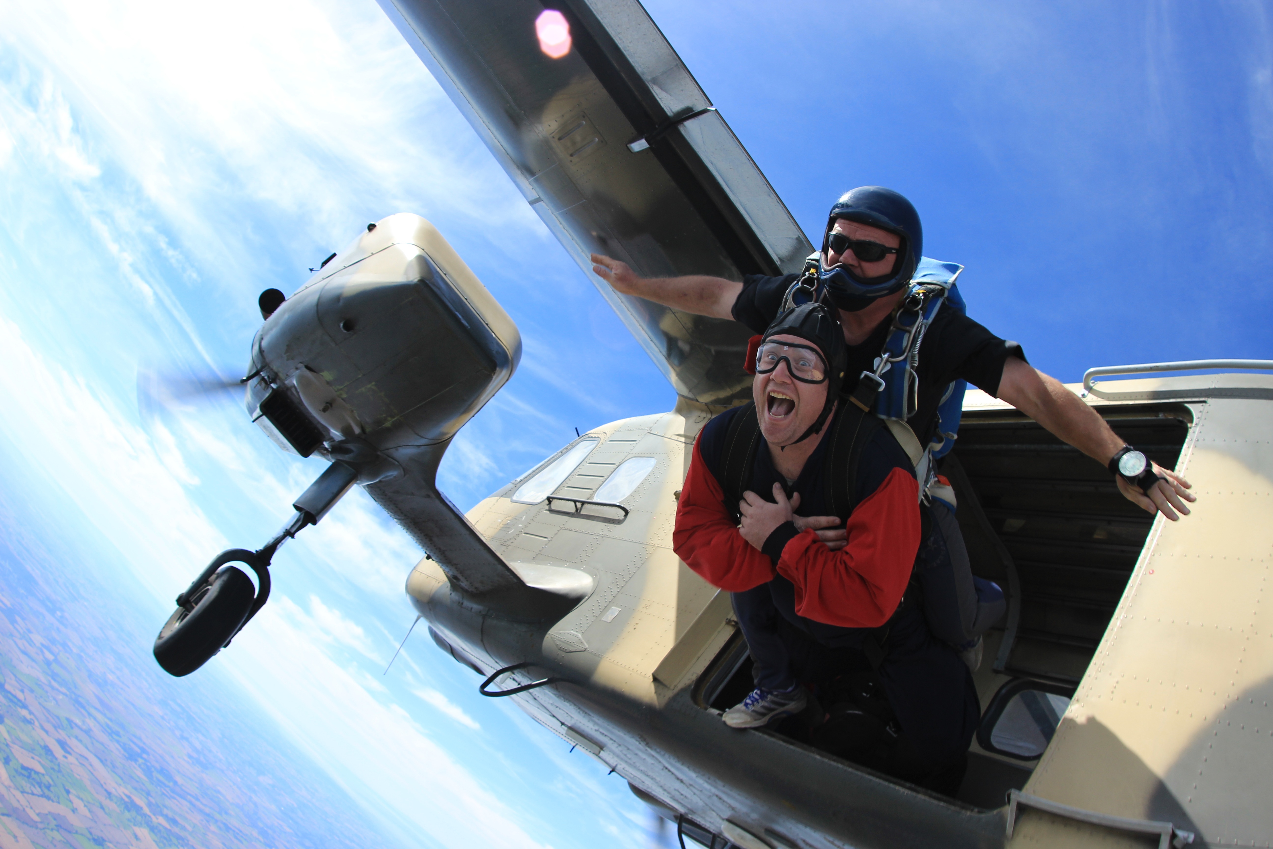 Skydivers in tandem jumping out of a plane