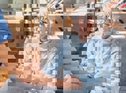 smiling older woman with glasses looking at paid care worker