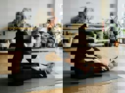 Woman stretching on a yoga mat at home.