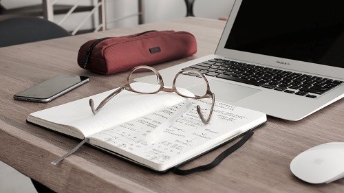 pair of glasses on a notebook on a desk
