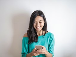 Smilng woman looks down at phone