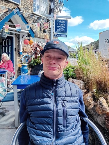 Photo of someone sitting in a chair outside of a pub