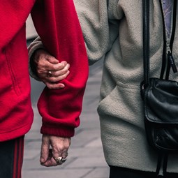 close up two people wearing fleeces linking arms