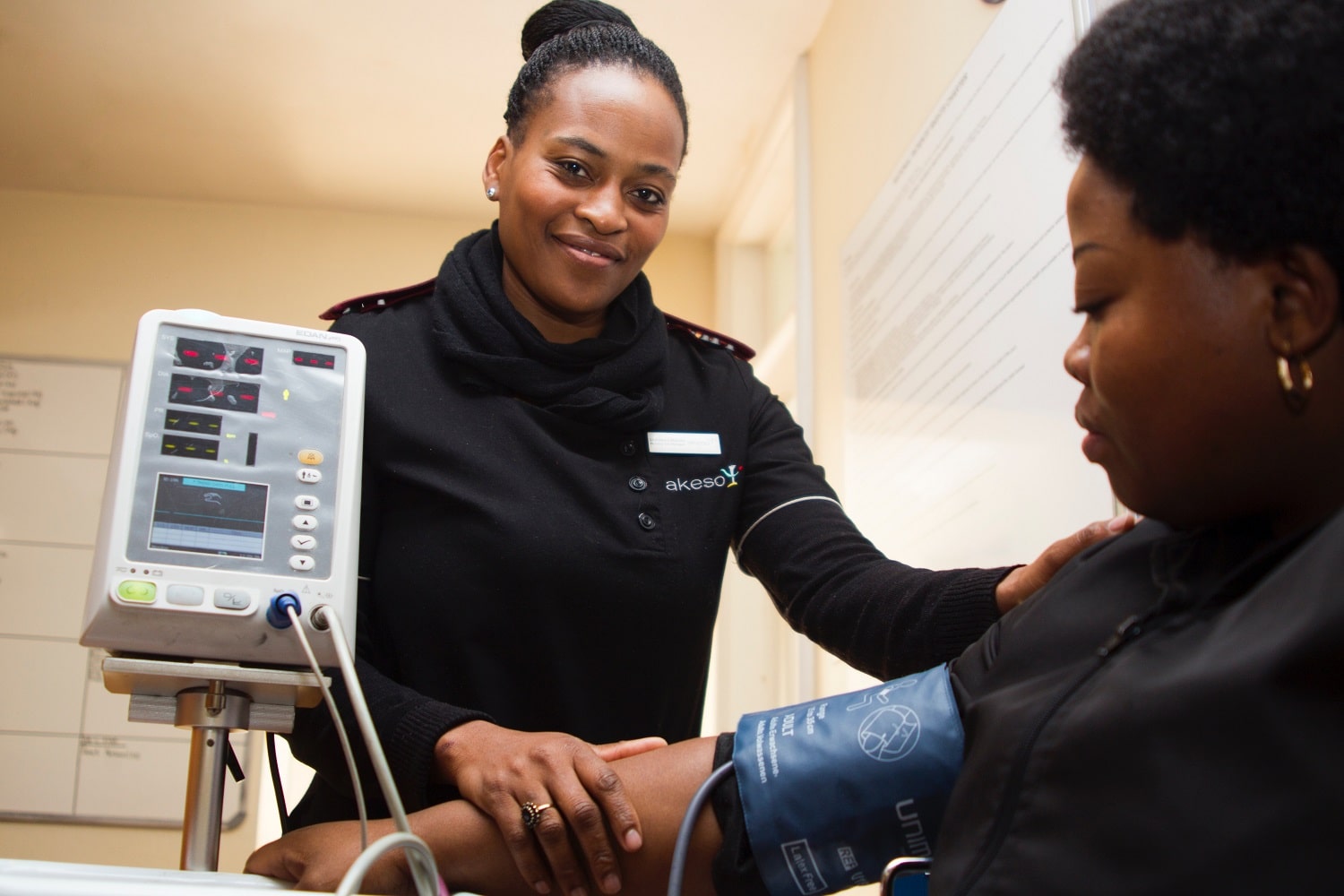 woman using blood pressure machine on patient
