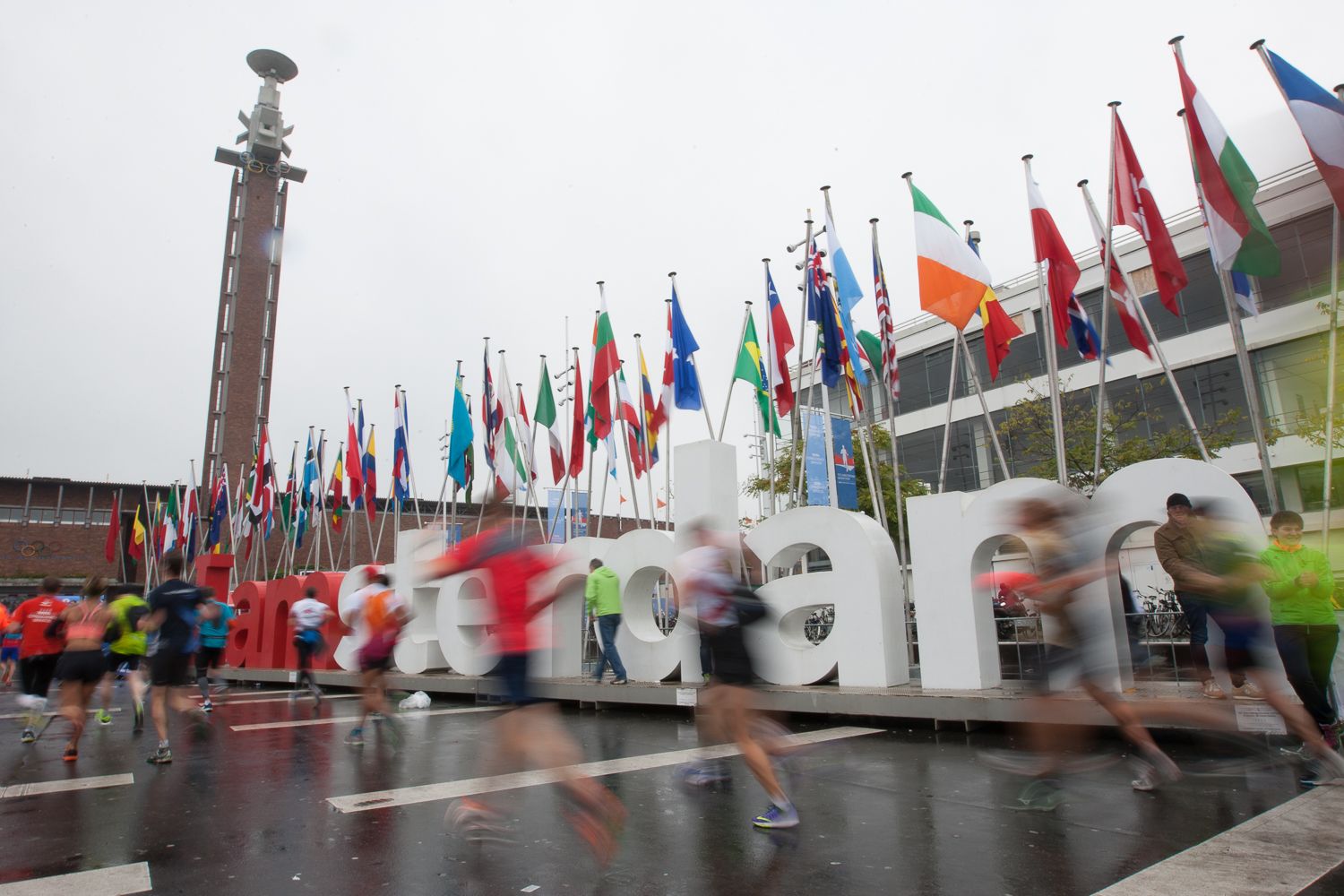 Runners passing Amsterdam sign