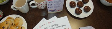 Cake and tea on a table with Looking after someone guide