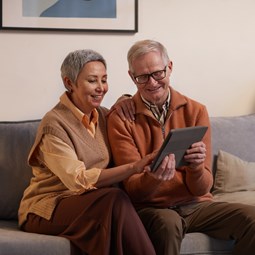 A man and a woman looking at a tablet together,