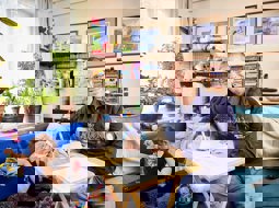 Carer at home, sitting at table with form, smiling